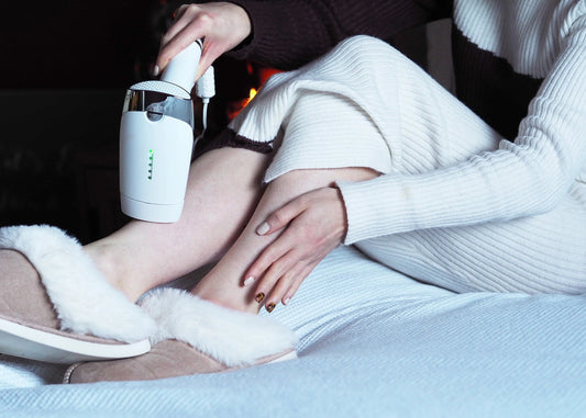A person using IPL hair removal on their legs
